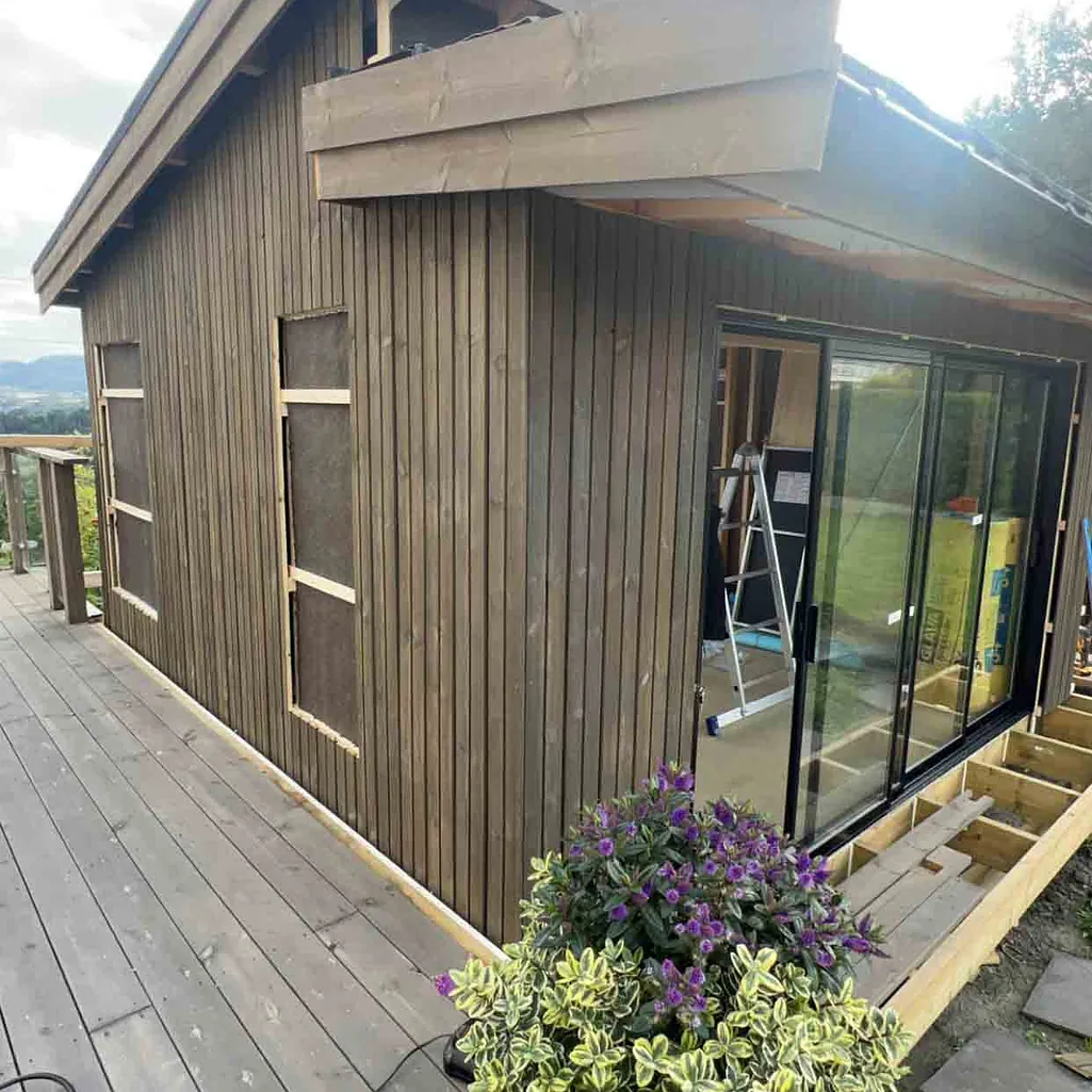 Brunt hus med stor terrasse