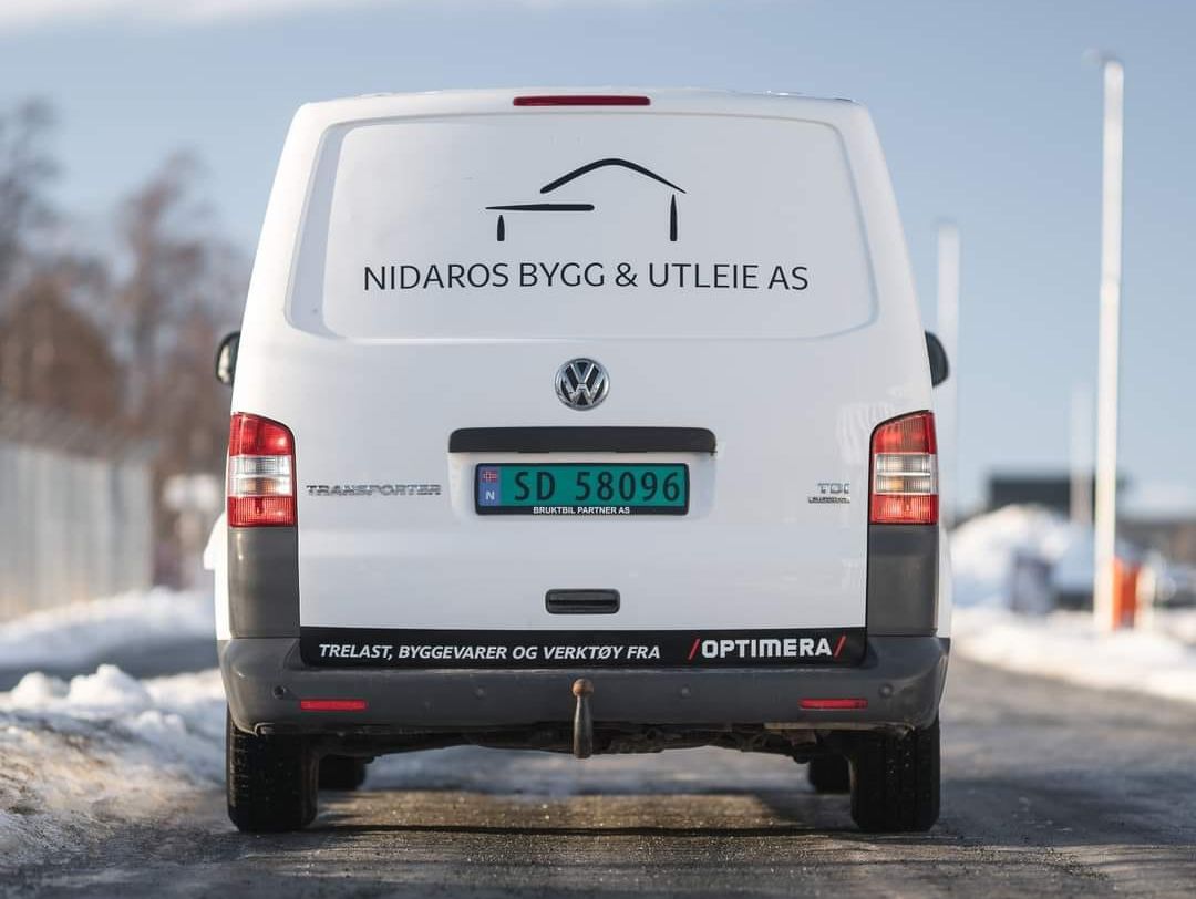 Bakende av hvit varebil med Nidaros Bygg & Utleie AS logo