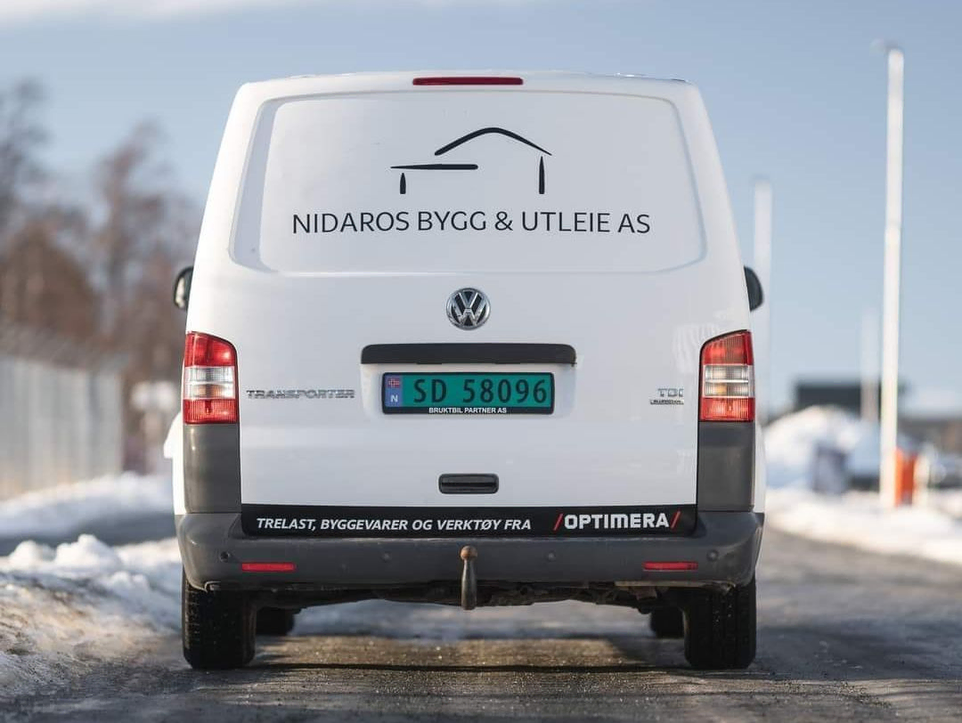 Bakende av hvit varebil med Nidaros Bygg & Utleie AS logo